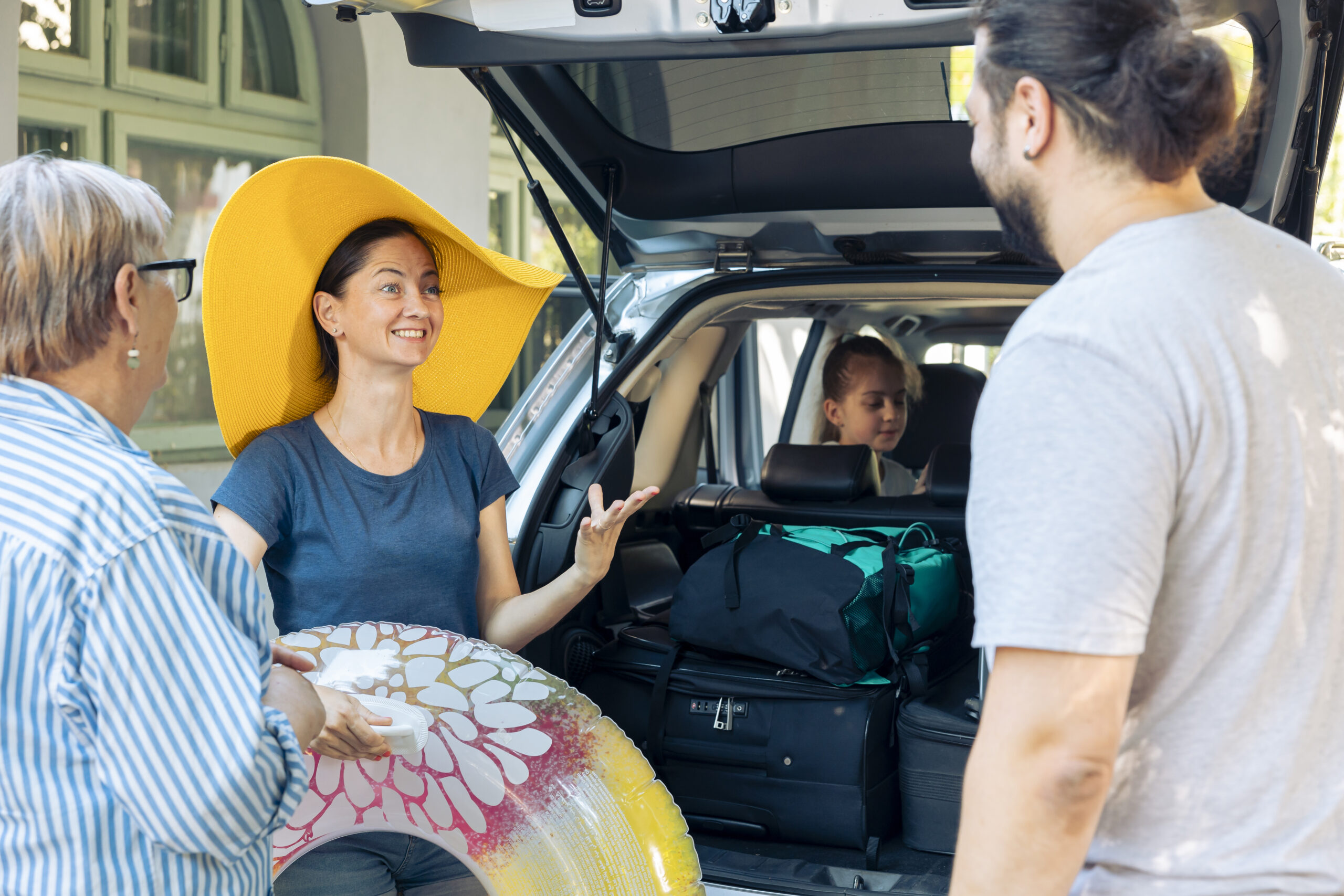 Family preparing for a South Carolina road trip with luggage packed in the rental vehicle
