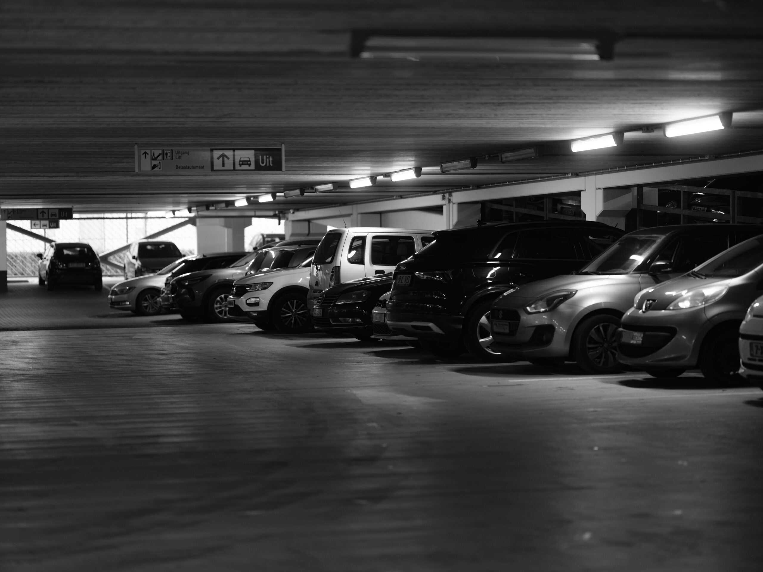 Rental car fleet parked in covered garage, offering a variety of vehicle options for travelers and families