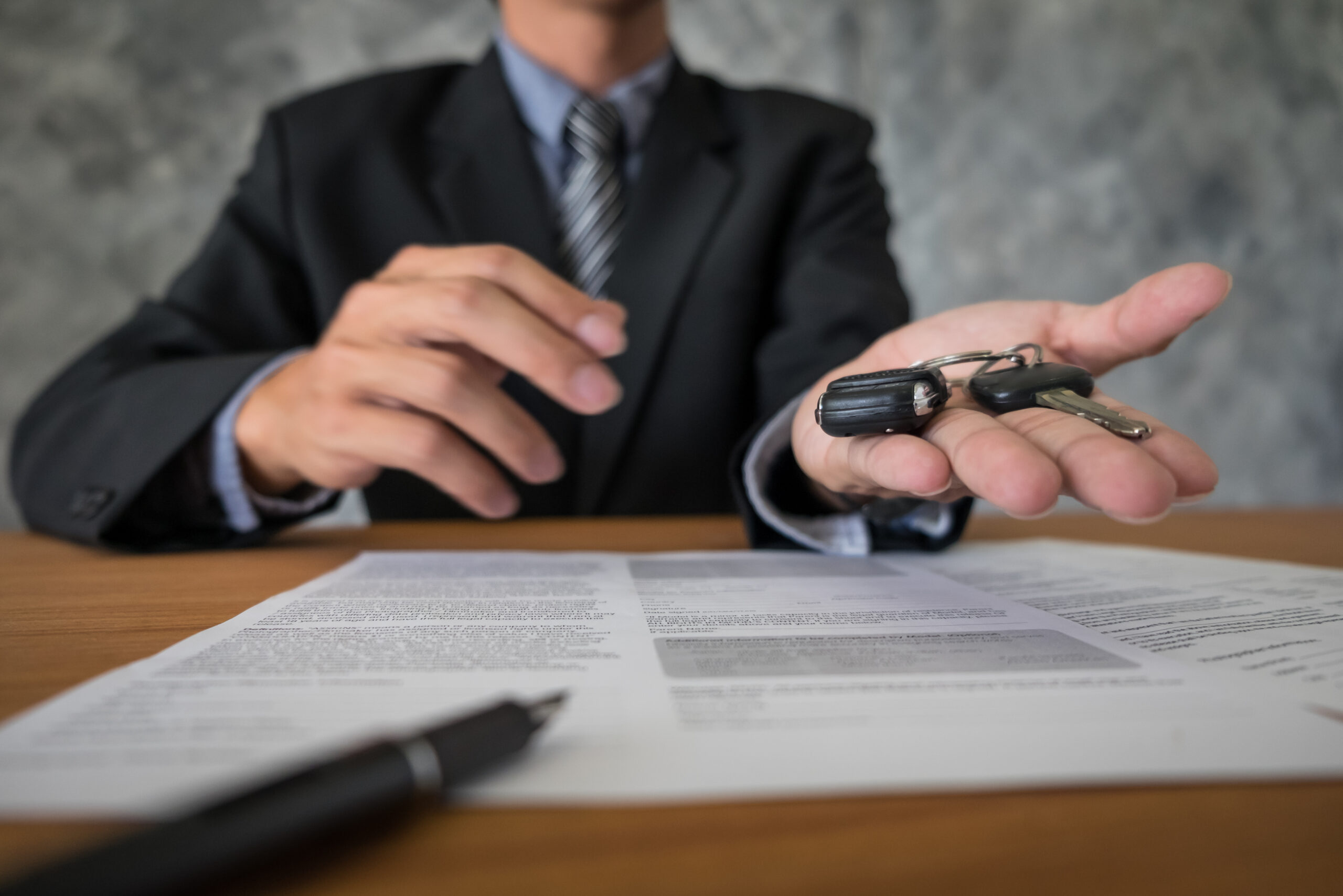 Customer reviewing rental paperwork and receiving keys before confirming rental car insurance options
