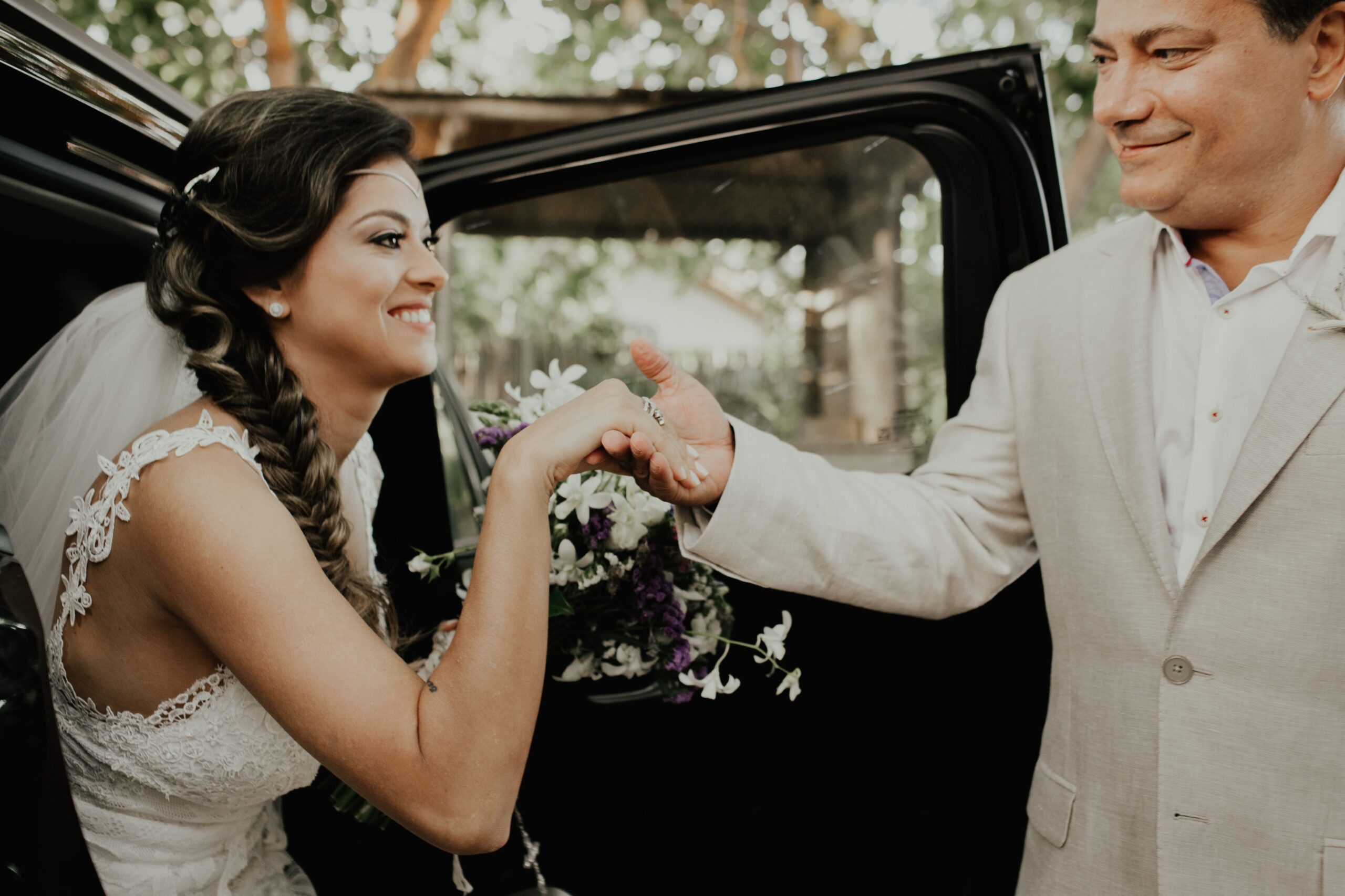 Wedding party stepping out of a rental SUV outside a Greenville venue